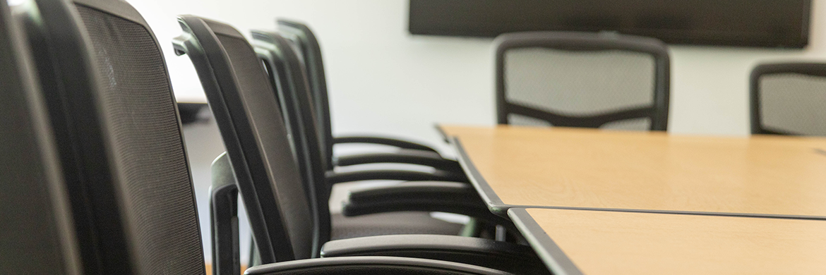 Meeting room image showing a table with several empty chairs