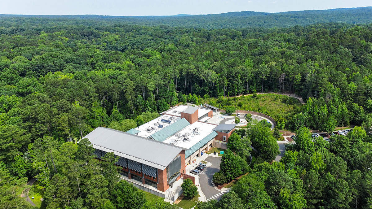 Pritchard Park aerial view showing an expansive park with a lush forest with the library building nestled in the middle