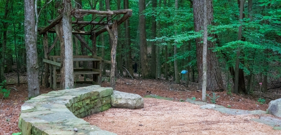 Outdoor classroom in the park showing a stone wall and wooden desk